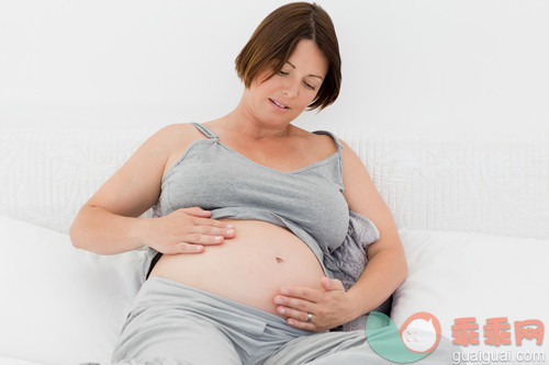 30岁到34岁,腹部,美女,床,卧室_gic9475423_Pregnant woman cuddling her belly at home_创意图片_Getty Images China