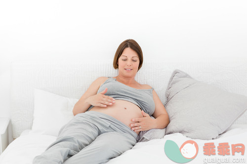 30岁到34岁,腹部,美女,床,卧室_gic9476586_Pregnant woman cuddling her belly at home_创意图片_Getty Images China