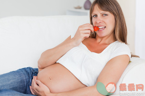 30岁到34岁,美女,美,肚子,碗_gic9736652_Charming pregnant woman eating strawberries while lying on her sofa_创意图片_Getty Images China