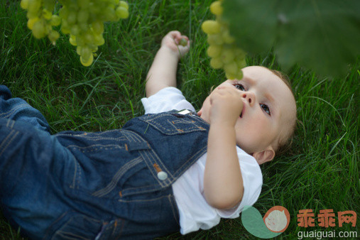 人,饮食,自然,四分之三身长,户外_164851262_Baby lying on grass looking up at grapes_创意图片_Getty Images China