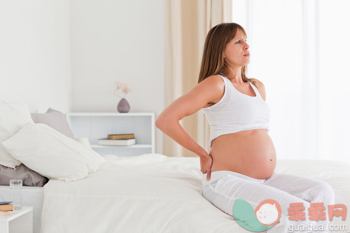 30岁到34岁,美女,美,床,卧室_gic9703376_Beautiful pregnant female having a back pain while sitting on a bed in her apartment_创意图片_Getty Images China