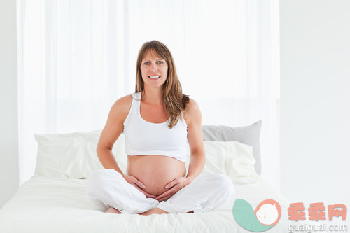 30岁到34岁,美女,美,床,卧室_gic9719693_Good looking pregnant female posing while sitting on a bed in her apartment_创意图片_Getty Images China