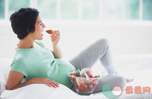 健康保健,营养品,饮食,健康食物,维生素_73506126_Woman in early stages of pregnancy reclining on sofa and eating strawberries out of glass bowl, side view._创意图片_Getty Images China