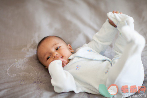 人,婴儿服装,床,室内,卧室_162744061_An Middle Eastern Culture baby holding his feet after waking up._创意图片_Getty Images China