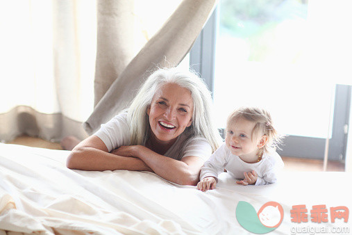 白色,人,休闲装,住宅内部,床_528843327_Mature woman playing with granddaughter on bed, portrait_创意图片_Getty Images China