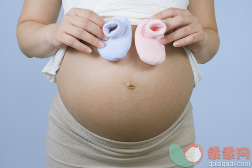 人,人生大事,影棚拍摄,室内,中间部分_88752221_Pregnant Chinese woman holding pink and blue booties_创意图片_Getty Images China