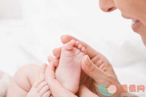 人,室内,40到44岁,人的脸部,快乐_126159917_Close-up of a mature woman holding her babys legs_创意图片_Getty Images China