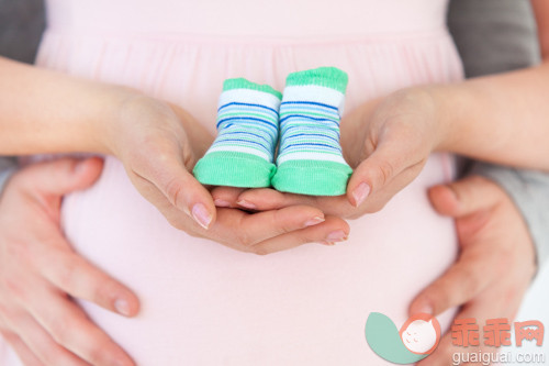 深情的,美女,美,肚子,迷人_gic7755667_Close-up of a pregnant woman holding baby shoes and of her husband at home_创意图片_Getty Images China