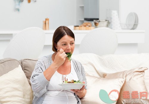 30岁到34岁,美女,美,肚子,碗_gic9089684_Pregnant woman eating vegetables on her sofa_创意图片_Getty Images China