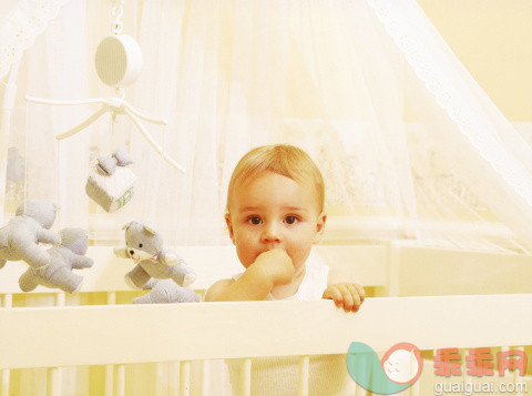 旋转盒,人,玩具,生活方式,室内_128242502_portrait of baby standing in cot_创意图片_Getty Images China