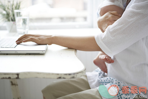 人,活动,住宅内部,电缆,计算机设备_gic16493884_Woman Computing While Holding Baby_创意图片_Getty Images China