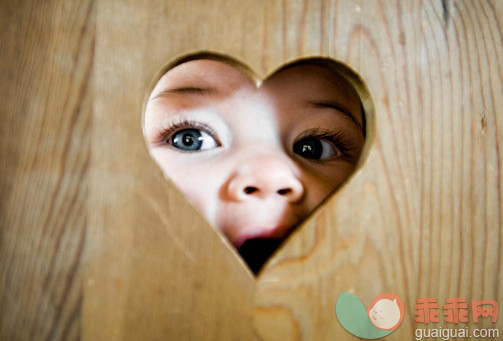 木制,人,人的脸部,睫毛,蓝色眼睛_123513545_Portrait of baby girl peeking through heart-shaped hole_创意图片_Getty Images China