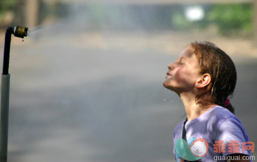 洒水机,人,户外,人的脸部,白人_128129013_A young girl leaning into a mister on a hot day_创意图片_Getty Images China