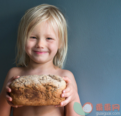 人,饮食,室内,面包,长发_560334627_Boy showing off homemade bread, smiling_创意图片_Getty Images China