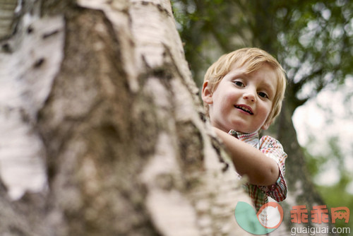 人,户外,白人,微笑,嬉戏的_gic14170035_Boy peeking from behind tree, looking at camera smiling_创意图片_Getty Images China