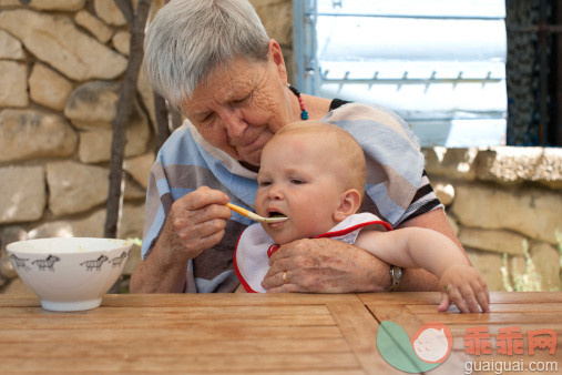 人,沟通,户外,碗,吃_483732913_grandmother giving food to a baby (1 year)_创意图片_Getty Images China