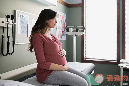 人,人生大事,健康保健,四分之三身长,室内_536907809_Pensive pregnant woman holding stomach in examination room_创意图片_Getty Images China