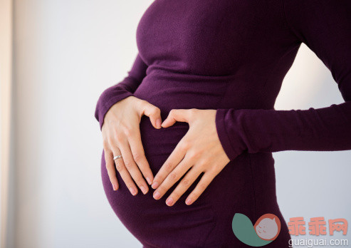 人,人生大事,室内,中间部分,25岁到29岁_487703585_Pregnant Caucasian woman making heart shape on belly_创意图片_Getty Images China