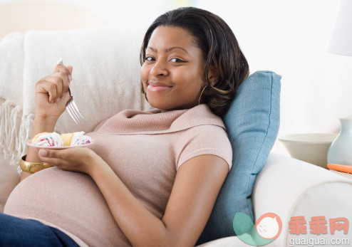 人,沙发,甜食,人生大事,生活方式_78568051_Pregnant African American woman eating cake_创意图片_Getty Images China