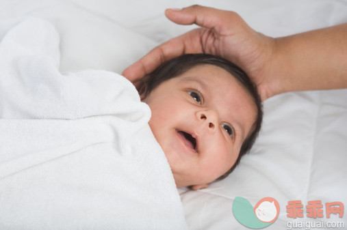 人,床,室内,20到24岁,深情的_140833717_Close-up of a baby lying on the bed_创意图片_Getty Images China