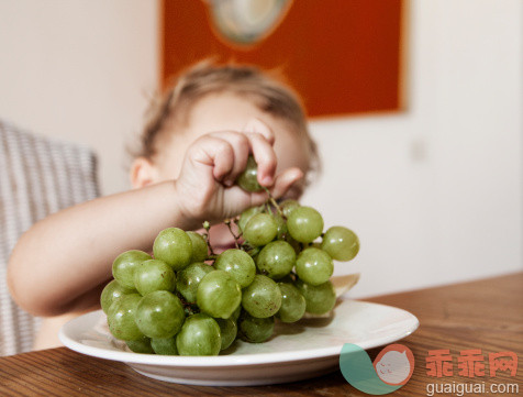人,桌子,饮食,室内,盘子_107246385_young girl catchs a grape from a plate_创意图片_Getty Images China