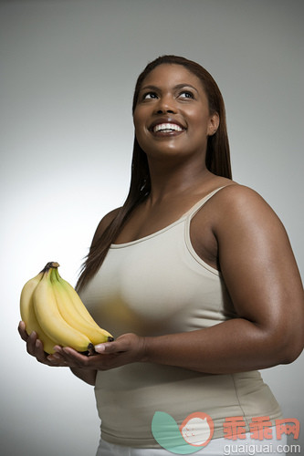 肖像,美,弯曲,阴影,微笑_gic15994747_Woman holding bananas_创意图片_Getty Images China