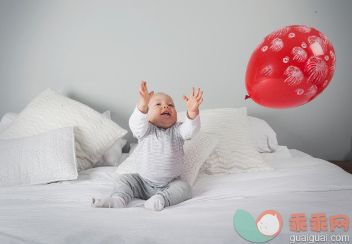 人,气球,床,生活方式,12到17个月_150639351_Baby boy playing with balloon on bed_创意图片_Getty Images China