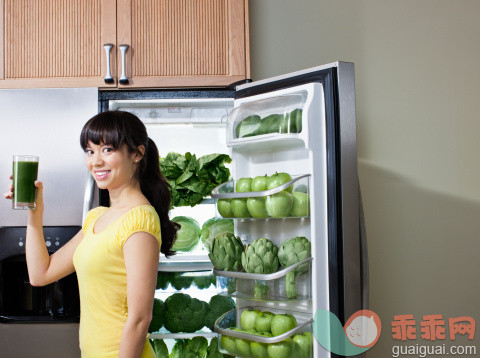 厨房,人,饮食,冰箱,生活方式_129301455_Mixed race woman drinking healthy drink near refrigerator_创意图片_Getty Images China