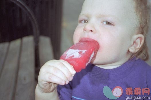 饮食,摄影,肖像,户外,红色_200021980-001_Baby boy (11-13 months) eating popsicle in park, portrait_创意图片_Getty Images China