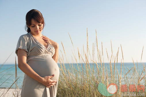 人,休闲装,环境,人生大事,自然_130409623_Pregnant woman holding her stomach on beach_创意图片_Getty Images China