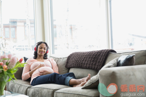 人,沙发,人生大事,生活方式,室内_497322799_Pregnant woman listening to headphones on sofa_创意图片_Getty Images China