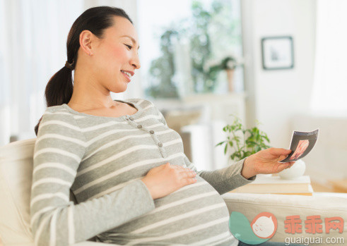 人,沙发,人生大事,技术,室内_482143977_Pregnant Japanese woman looking at ultrasound image_创意图片_Getty Images China