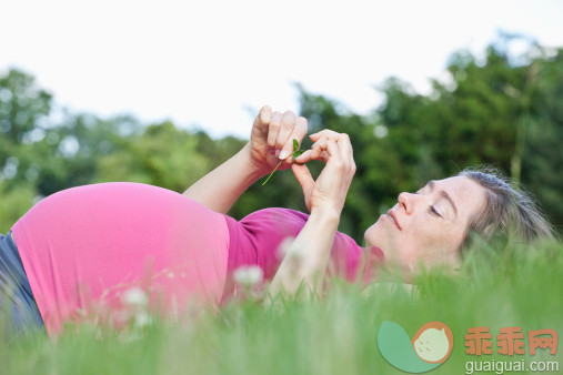 人,休闲装,人生大事,生活方式,自然_145065287_A pregnant woman lying in the grass, side view_创意图片_Getty Images China