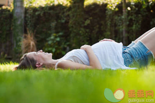 人,衣服,休闲装,短裤,人生大事_139266844_Young pregnant woman lying on grass_创意图片_Getty Images China