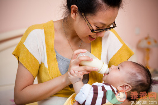 人,饮食,休闲装,室内,25岁到29岁_123992764_Mother feeding her baby with milk bottle_创意图片_Getty Images China