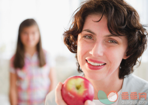 人,饮食,休闲装,食品,生活方式_137064087_Mother holding apple, daughter in background_创意图片_Getty Images China