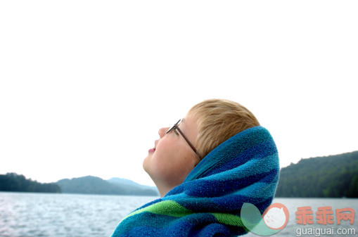 人,户外,毛巾,眼镜,白昼_113220591_A boy leans his head back while enjoying a boat ride._创意图片_Getty Images China