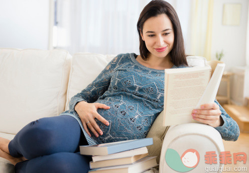 人,沙发,人生大事,生活方式,四分之三身长_487703501_Pregnant Caucasian woman reading baby books on sofa_创意图片_Getty Images China