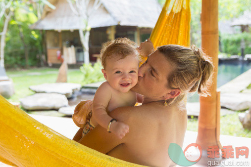 人,度假,2到5个月,户外,40到44岁_487700877_Caucasian mother kissing baby in hammock_创意图片_Getty Images China