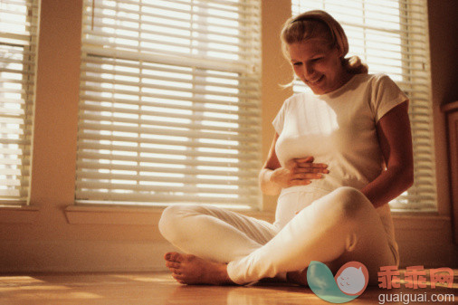 人生大事,摄影,颜色处理,阶调图片,坐_57572083_Pregnant woman sitting on the floor touching her abdomen_创意图片_Getty Images China