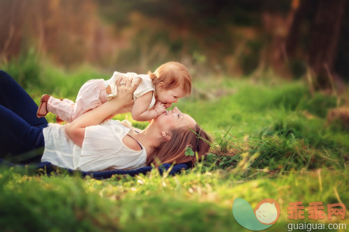 人,四分之三身长,户外,25岁到29岁,深情的_gic17955079_woman laying in the grass playing with her one year old daughter_创意图片_Getty Images China