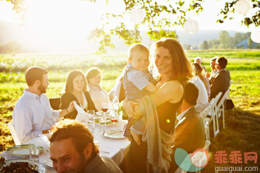 人,饮食,桌子,户外,20到24岁_128374635_Mother holding baby next to outdoor banquet table_创意图片_Getty Images China