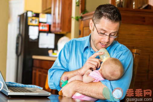 厨房,人,休闲装,住宅内部,桌子_512059345_Father feeding baby bottle while attempting to work from home_创意图片_Getty Images China