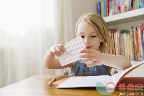 金色头发,书架,写实,白人,窗帘_gic14833630_Portrait of girl (4-5) sitting at table and holding stickers_创意图片_Getty Images China