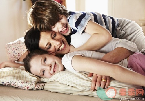 35岁到39岁,40到44岁,搂着肩膀,床,床上用品_gic14872928_Portrait of mother with daughter (10-12) and son (8-9) lying on bed_创意图片_Getty Images China