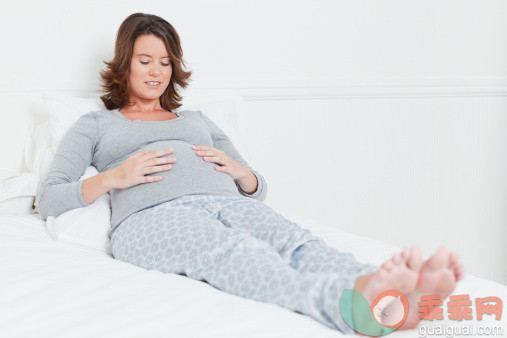 人,床,二件式睡衣,人生大事,生活方式_148198403_Woman holding pregnant belly on bed_创意图片_Getty Images China