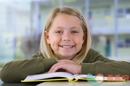 室内,人,肖像,坐,微笑_gic16376683_Girl (9-11) reading textbook at desk in classroom, smiling, close-up, front view, portrait_创意图片_Getty Images China