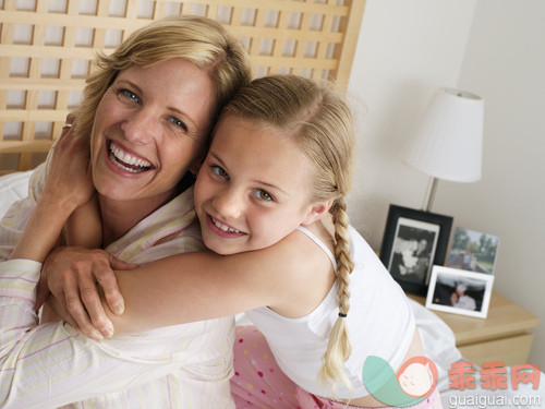 室内,人,住宅房间,拿着,坐_gic16383369_Mother and daughter (6-8) sitting on double bed at home, girl embracing woman, smiling, close-up, portrait (tilt)_创意图片_Getty Images China