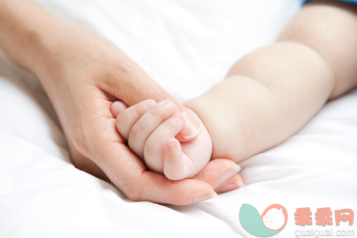 人,休闲装,床,室内,25岁到29岁_488609401_Mother holding baby's hand in bed_创意图片_Getty Images China