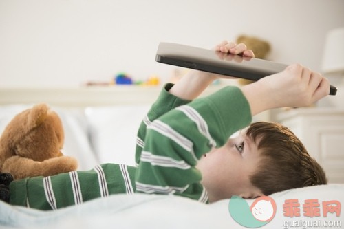 床,卧室,棕色头发,白人,衣服_gic14784604_Boy (4-5) lying down on bed and holding digital tablet_创意图片_Getty Images China